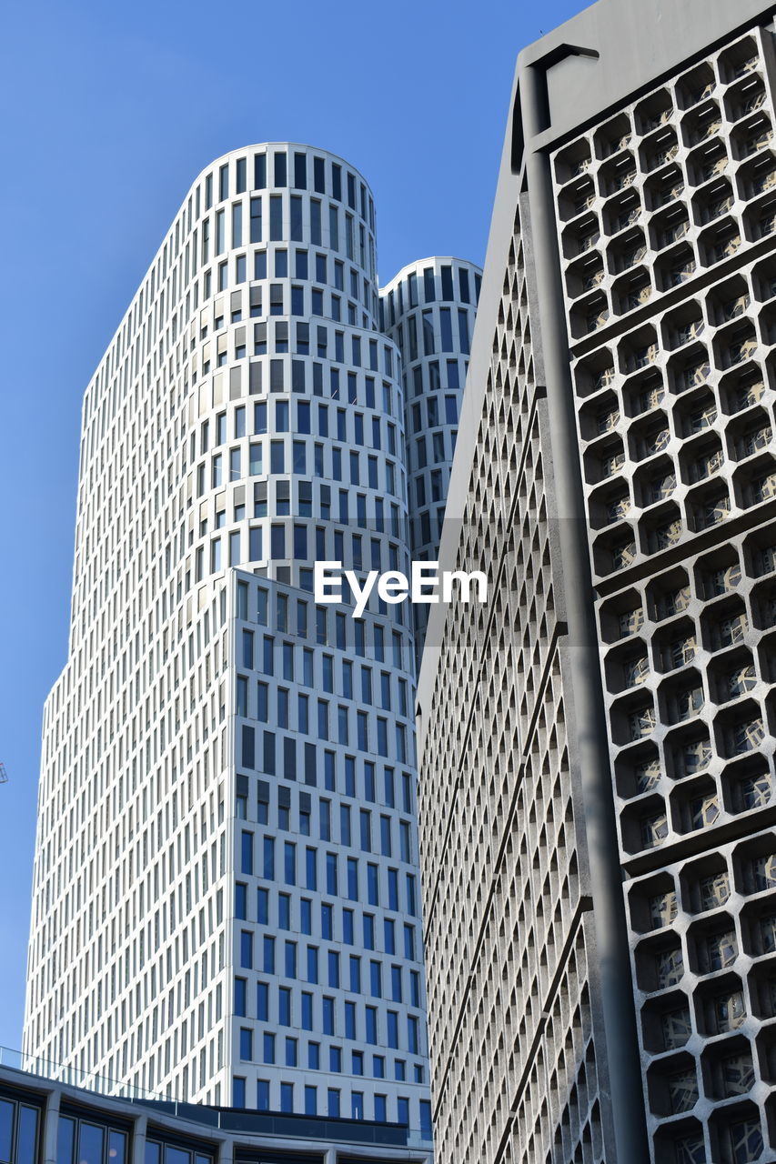 Low angle view of modern buildings against clear blue sky