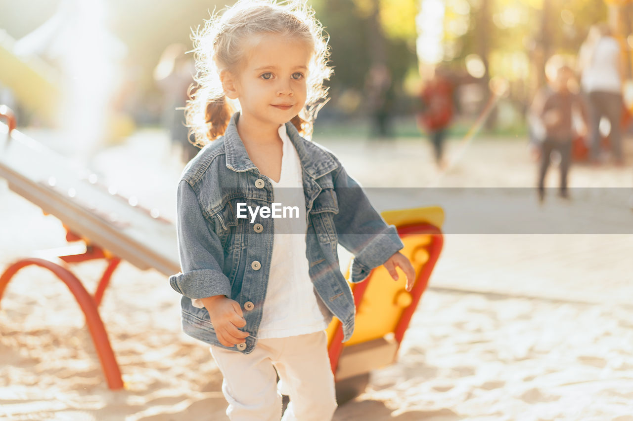 Cute girl looking away while walking at playground