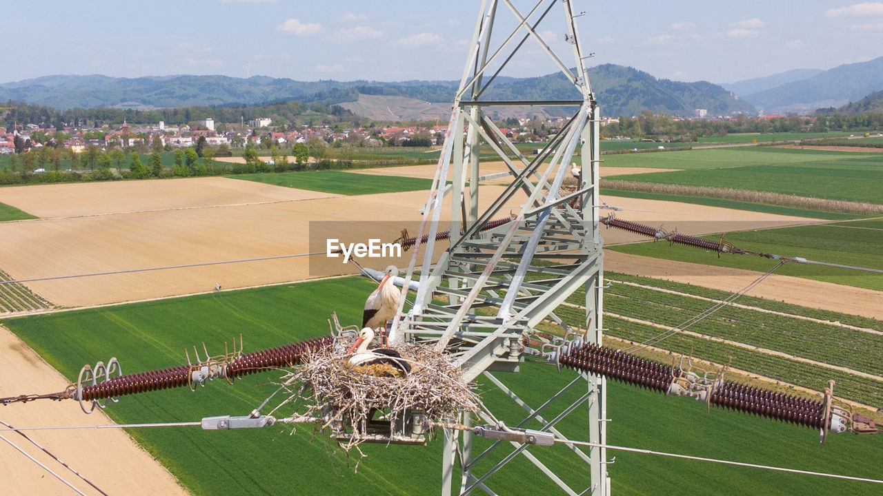 HIGH ANGLE VIEW OF METALLIC STRUCTURE ON FIELD AGAINST SKY