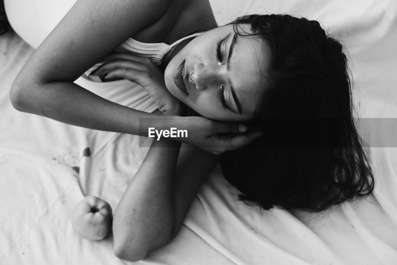 Young woman lying on bed at home