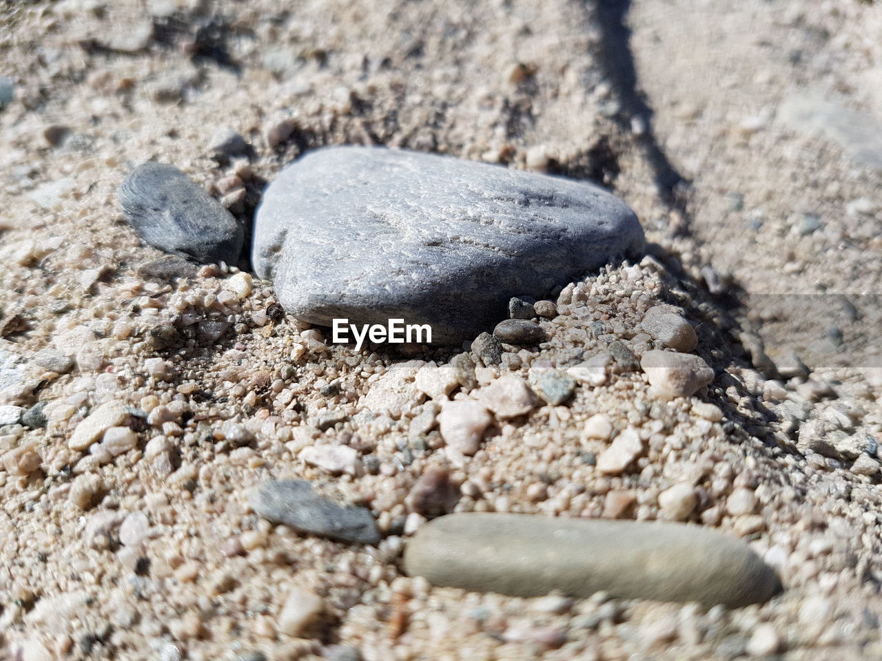 CLOSE-UP OF PEBBLE ON SAND