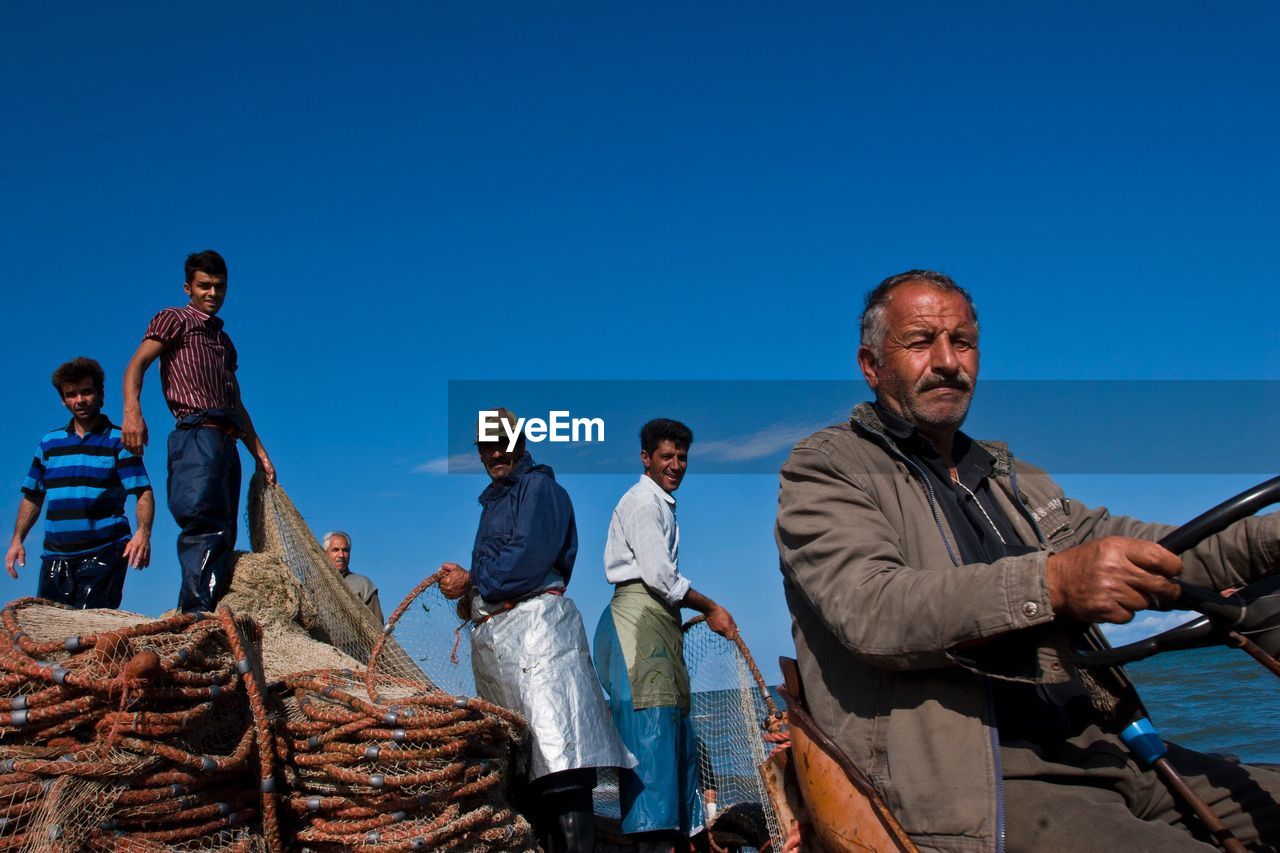 Man riding vehicle with fishermen in background