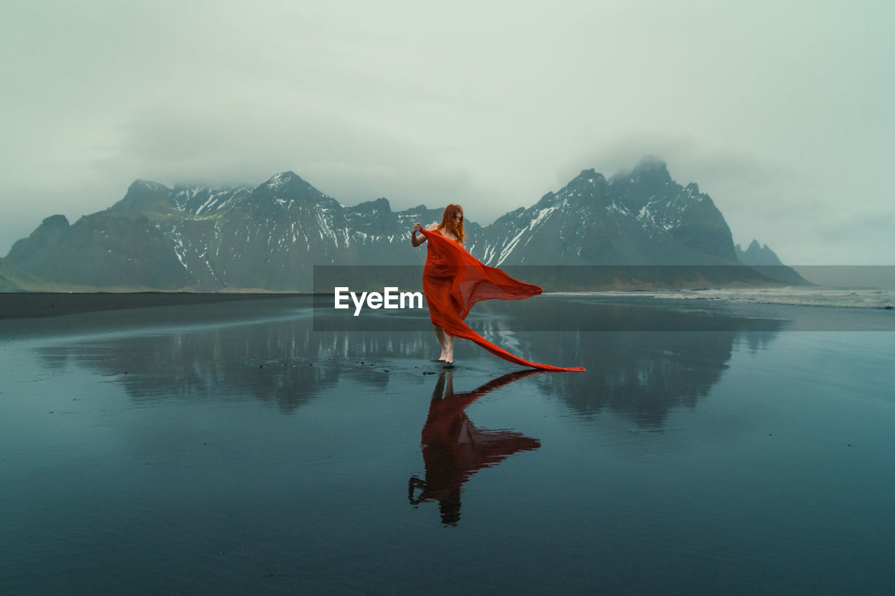 Model in elegant gown on reynisfjara beach scenic photography