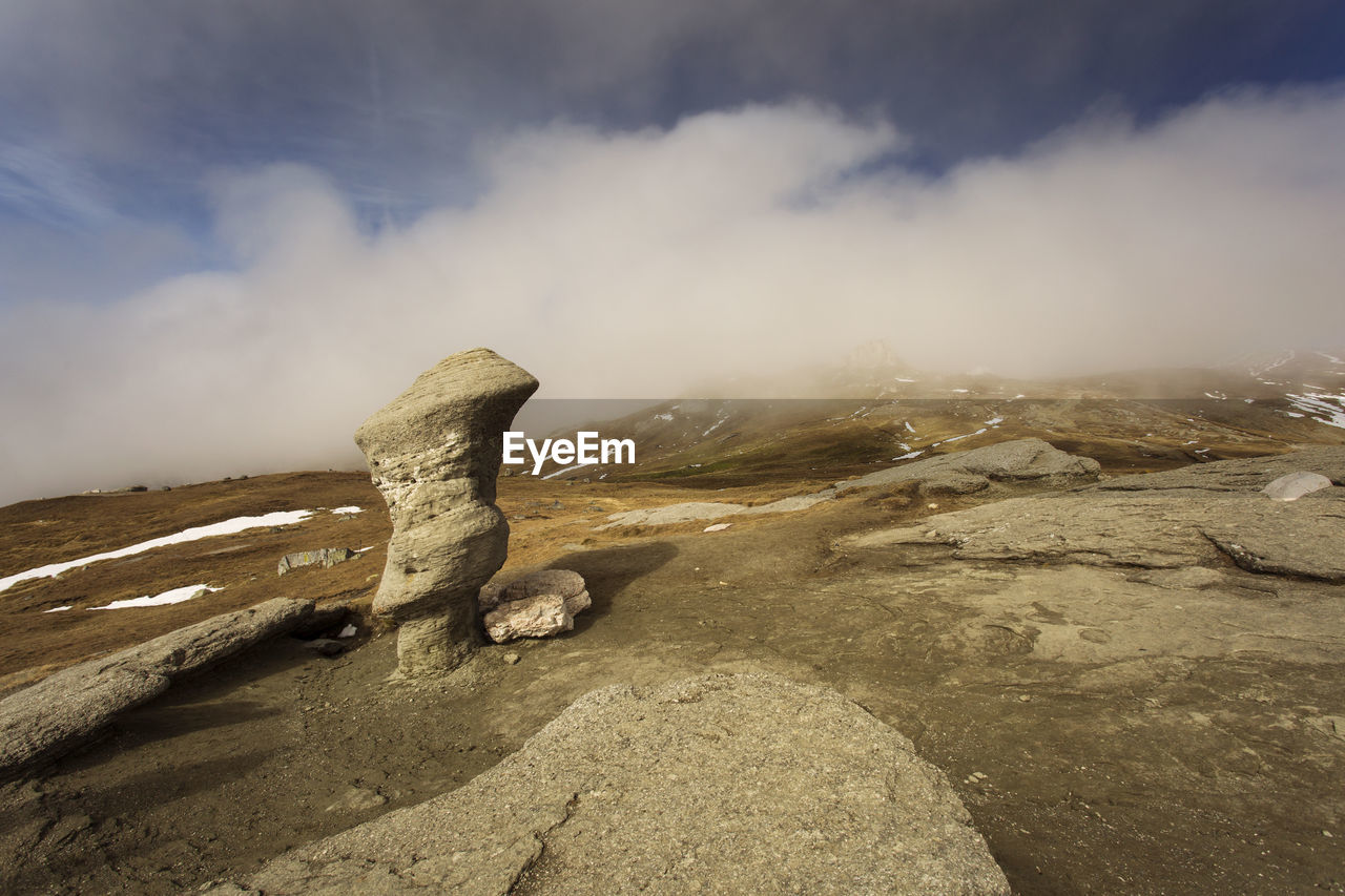 SCENIC VIEW OF ROCK ON LANDSCAPE AGAINST SKY