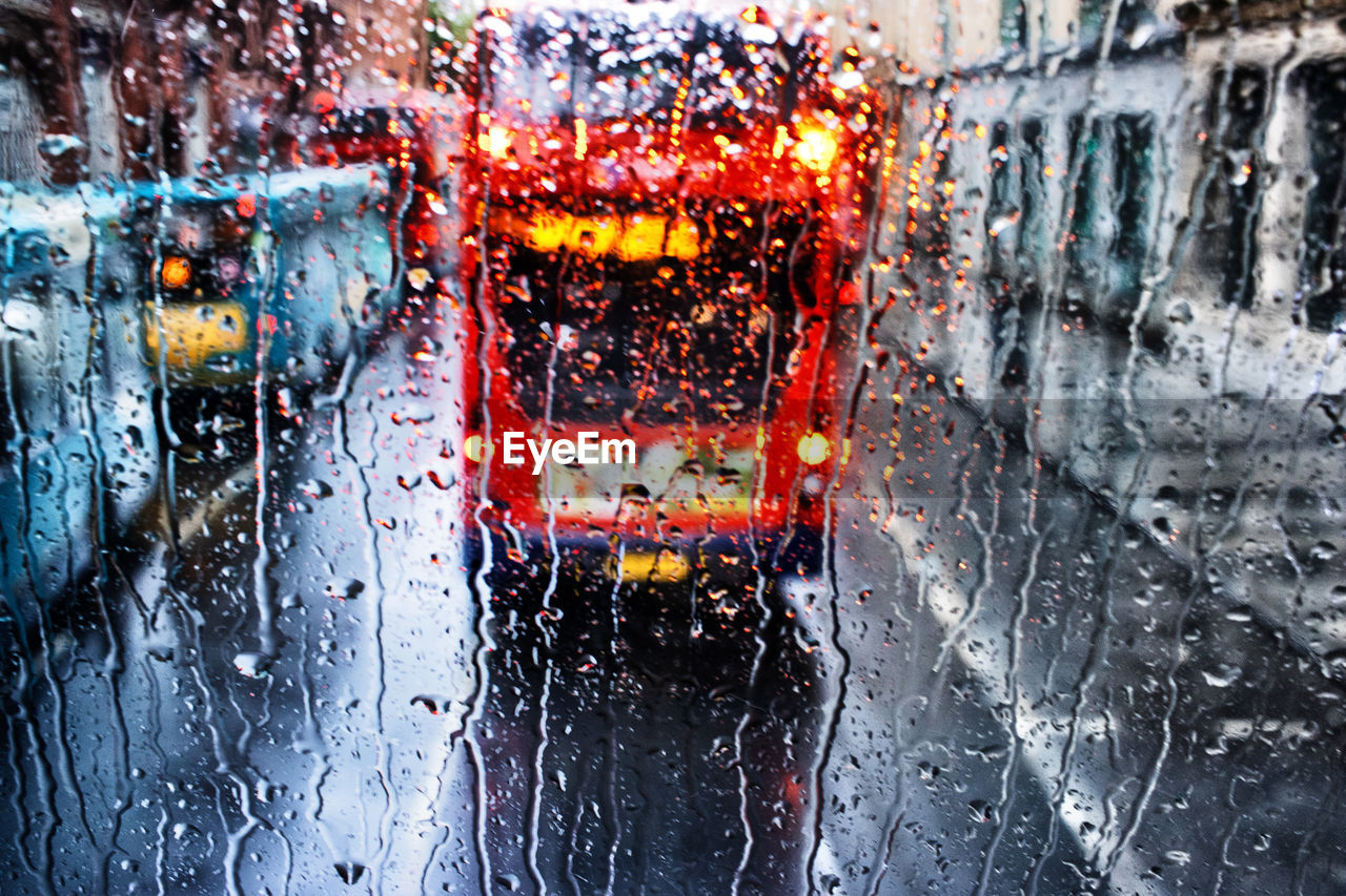 wet, drop, rain, mode of transportation, car, transportation, glass, motor vehicle, water, land vehicle, window, city, transparent, rainy season, architecture, vehicle interior, raindrop, street, nature, monsoon, car interior, indoors, no people, traffic, full frame, built structure, windshield, close-up, road, snow, backgrounds, city street, winter, city life, illuminated, day, tail light, travel, reflection, on the move, motion