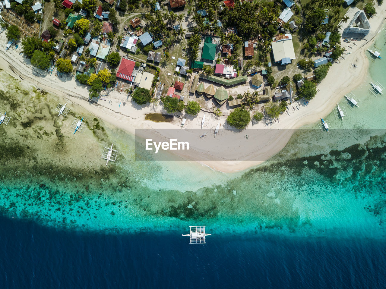 Bird's eye drone picture of a boat in the clear waters of pamilacan island, bohol, philippines