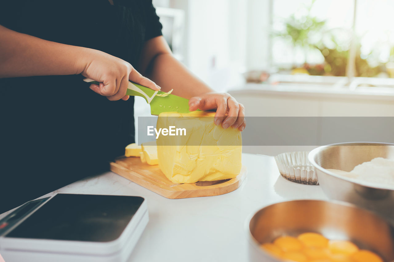 Midsection of woman preparing food at home