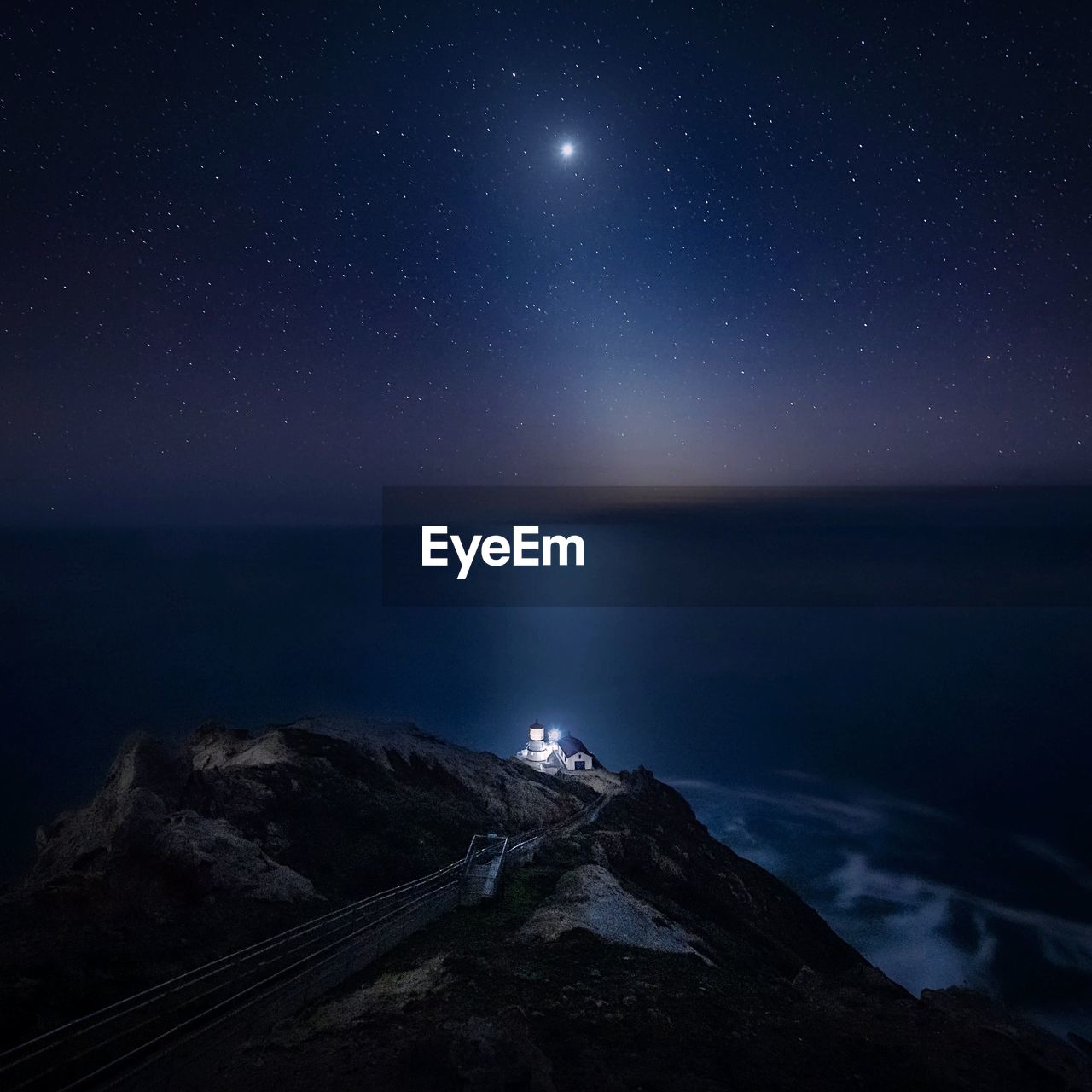 Aerial view of cliff by sea against sky at night