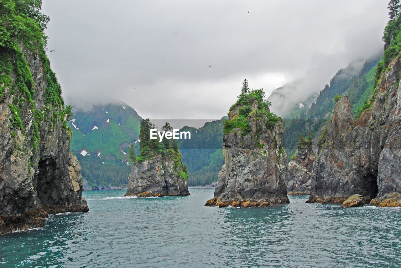 Panoramic shot of rocks in sea against sky