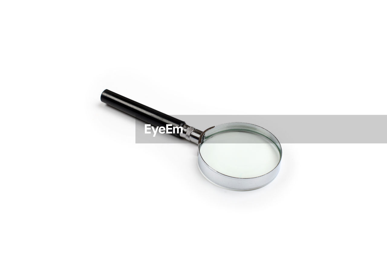 High angle view of magnifying glass over white background