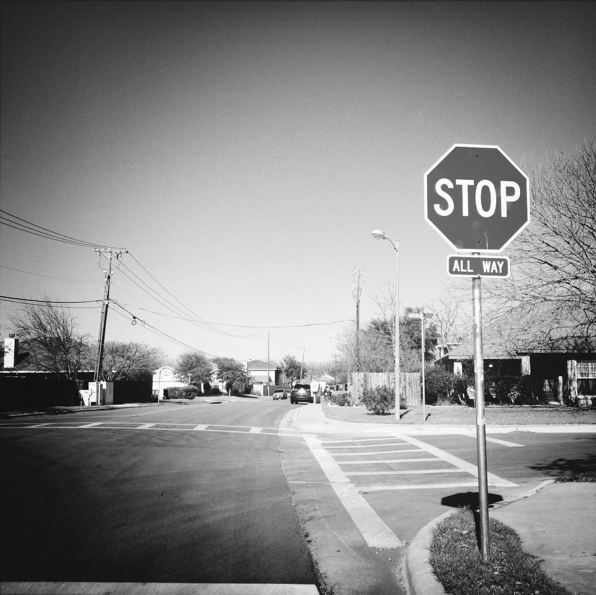 Stop sign by road at city against clear sky