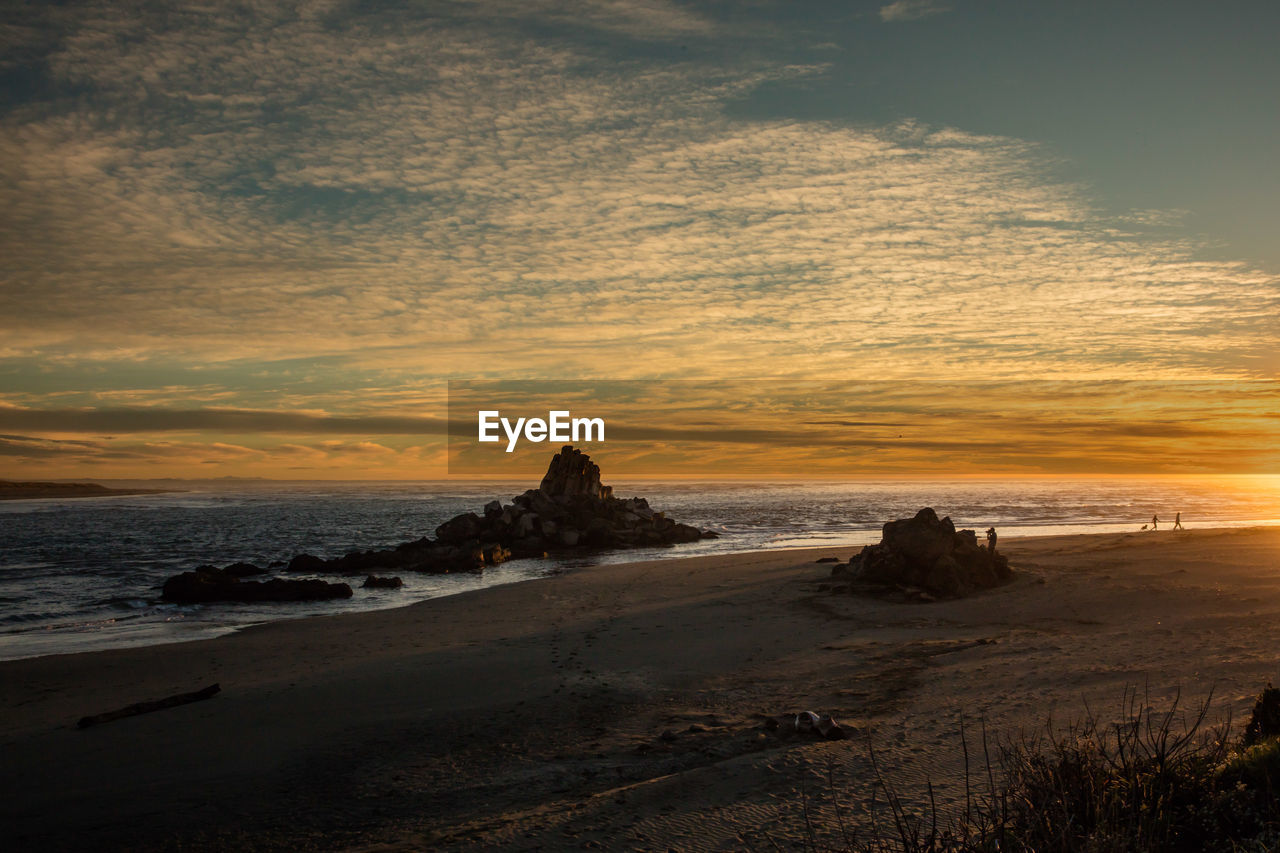 Scenic view of beach against sky during sunset