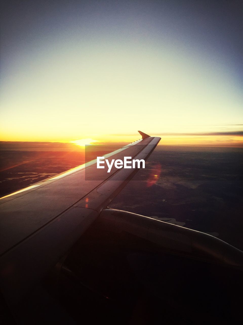 Airplane wing with sunset in background