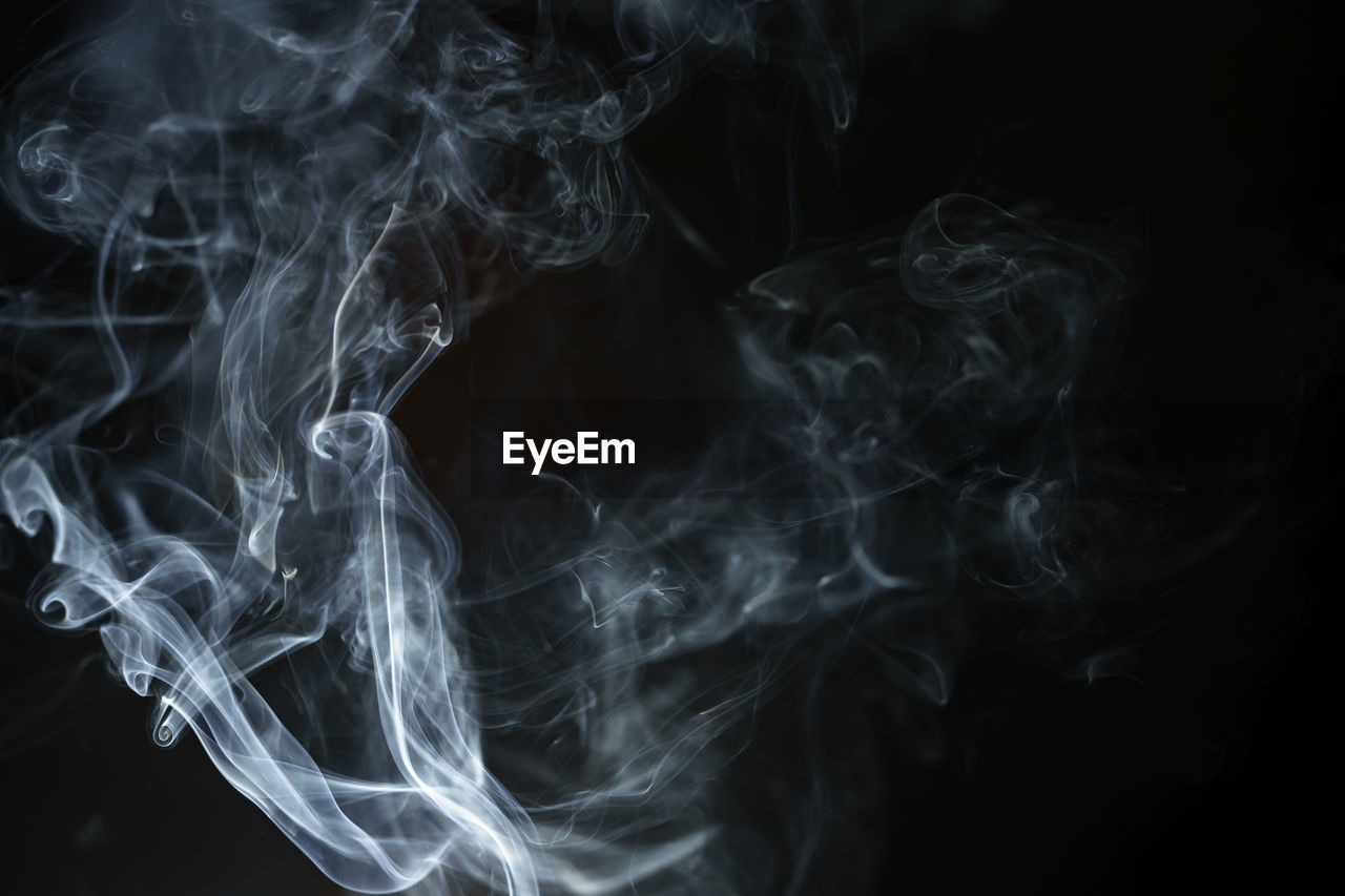 Abstract smoke from incense and light in a black background