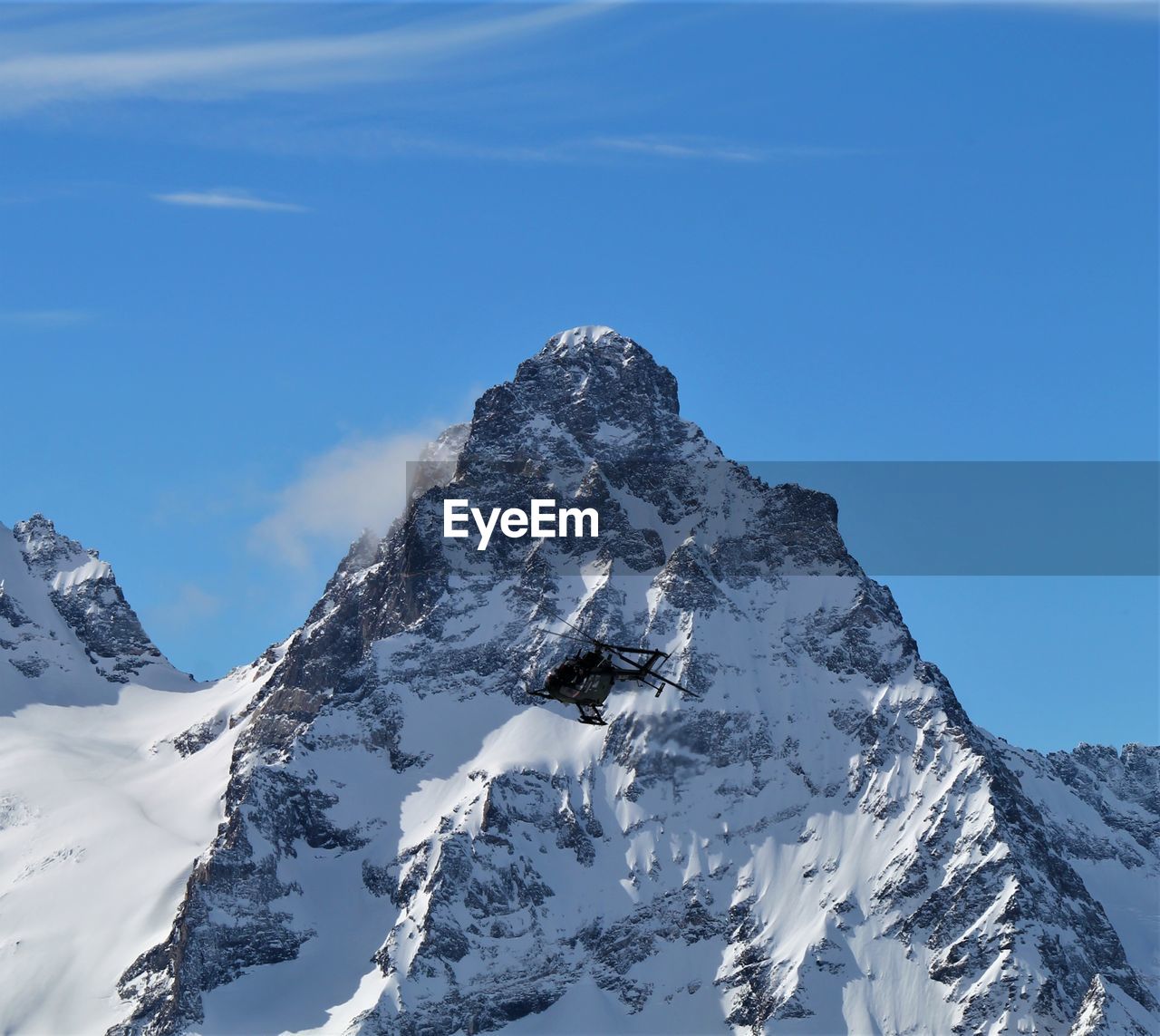 Scenic view of snowcapped mountain against blue sky