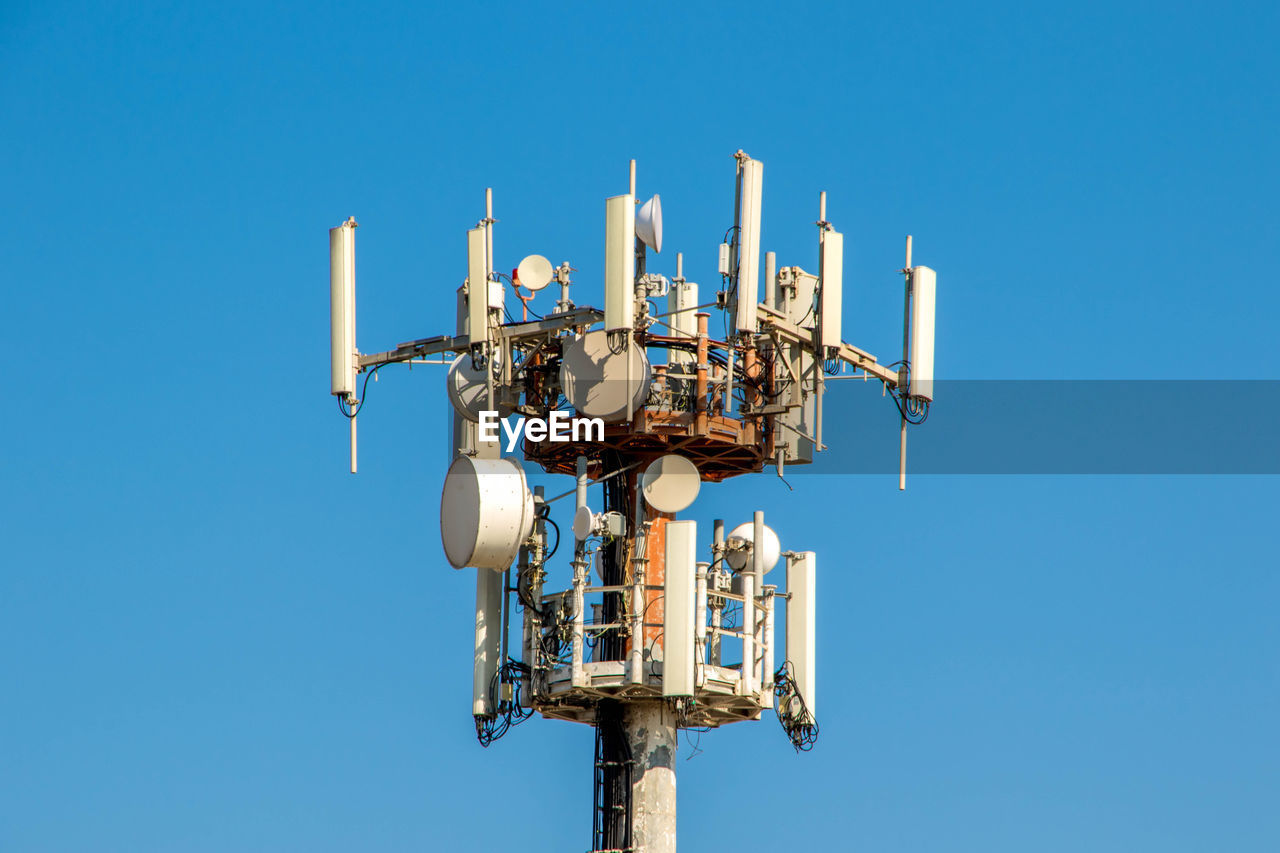 Low angle view of communications tower against clear blue sky