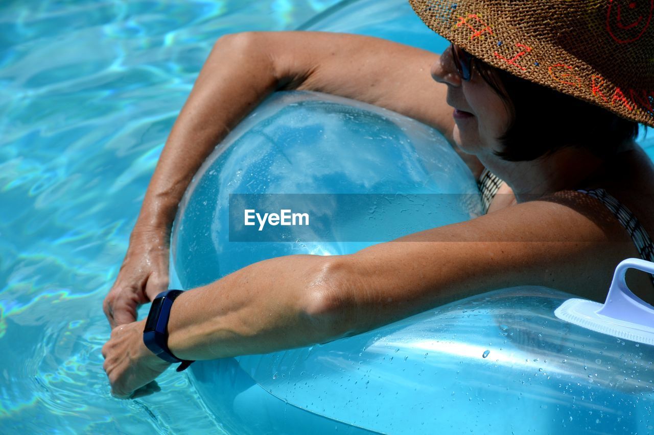 High angle view of woman on inflatable in swimming pool