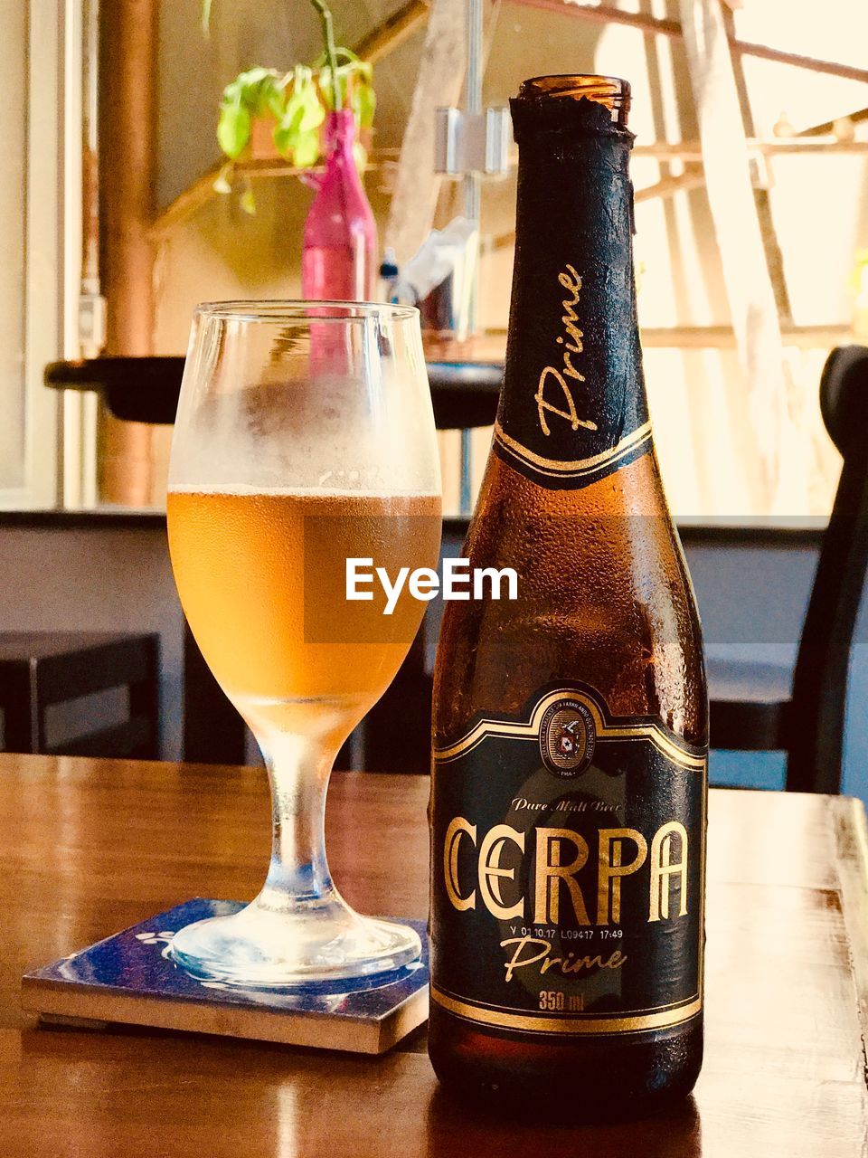 CLOSE-UP OF BEER BOTTLE ON TABLE