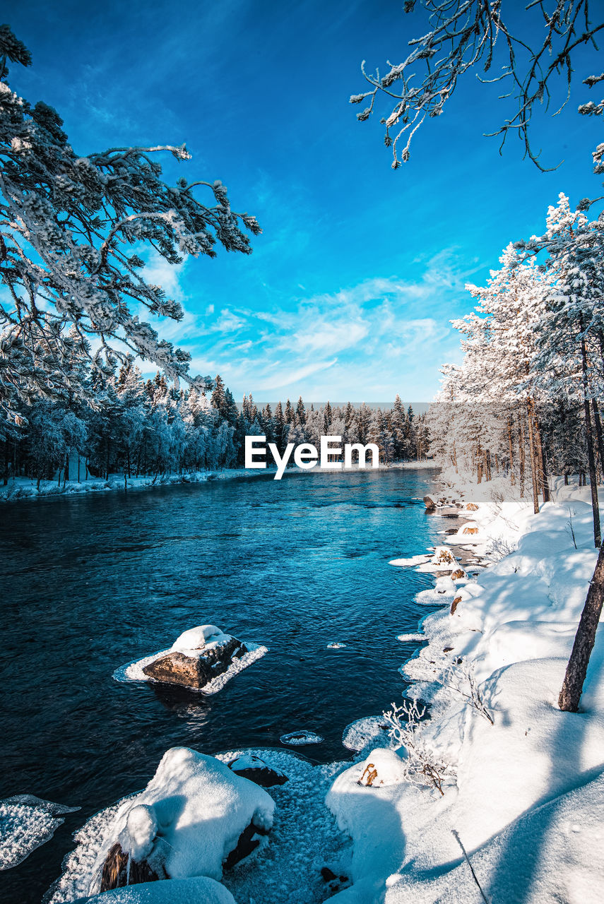 Scenic view of river against sky during winter