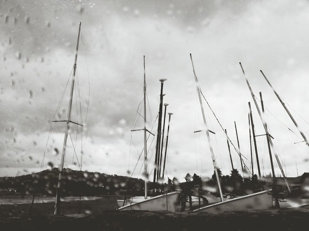Yachts moored at harbor in rain