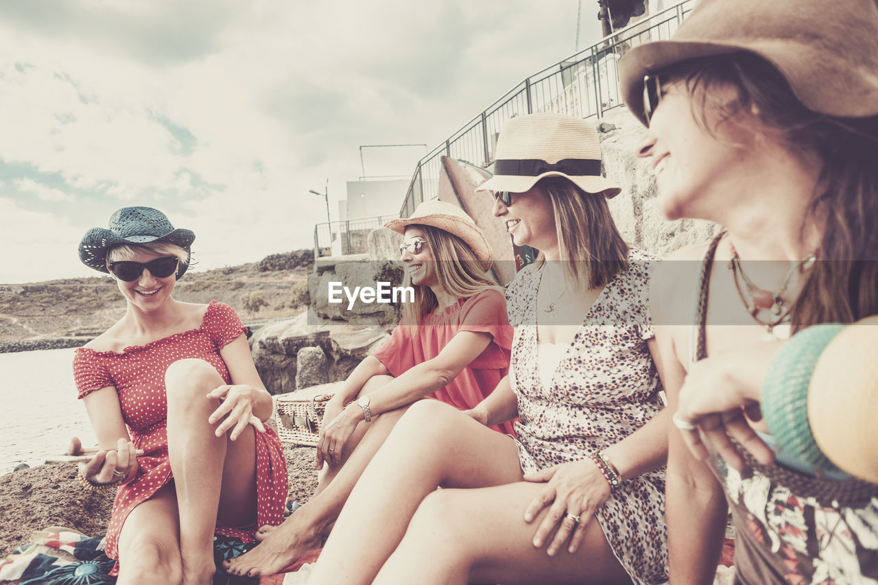 Smiling friends sitting outdoors