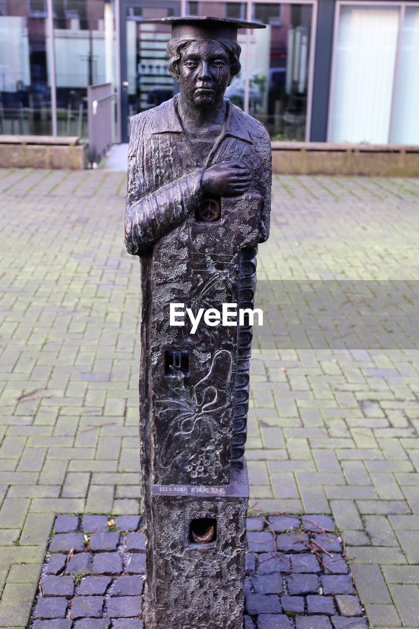 CLOSE-UP PORTRAIT OF STATUE AGAINST CITY