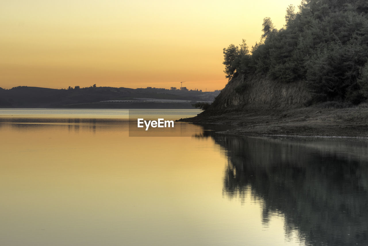 Scenic view of lake against sky at sunset