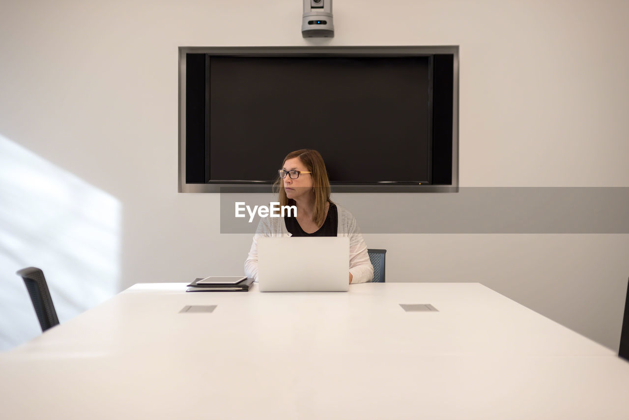 Businesswoman using laptop on table at office