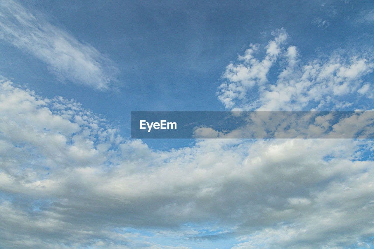 Blue sky background with tiny clouds