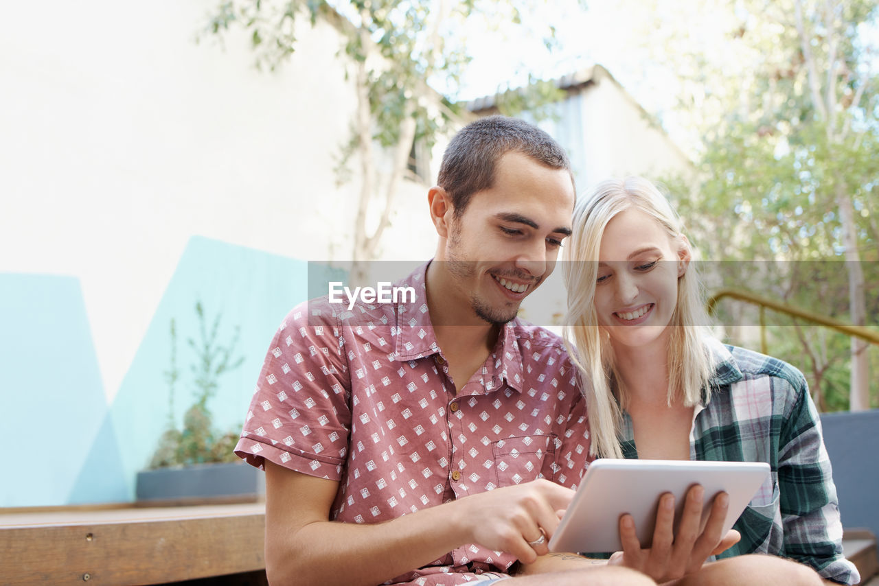 Smiling couple looking at digital tablet