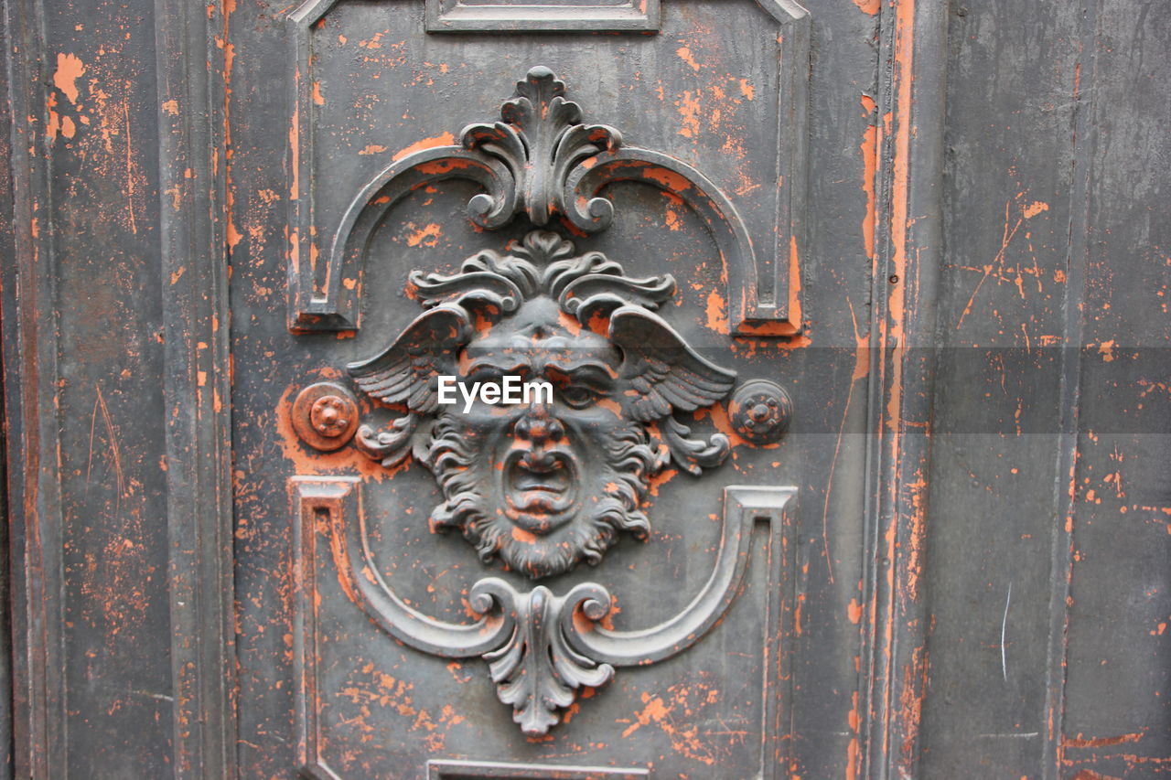 Close-up of face carving on door