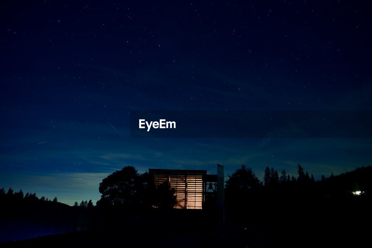 Low angle view of silhouette building against sky at night