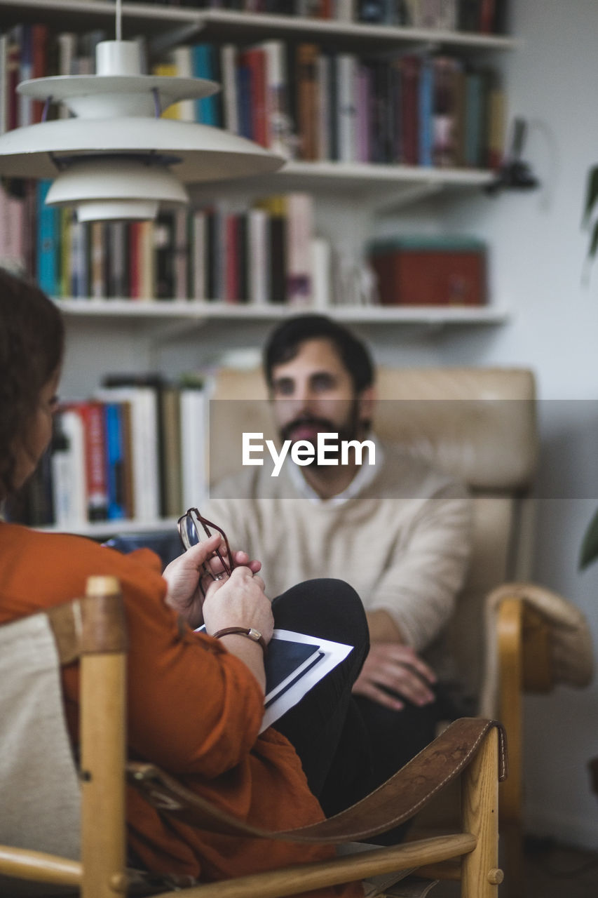 Female therapist with male patient during therapy session at home office