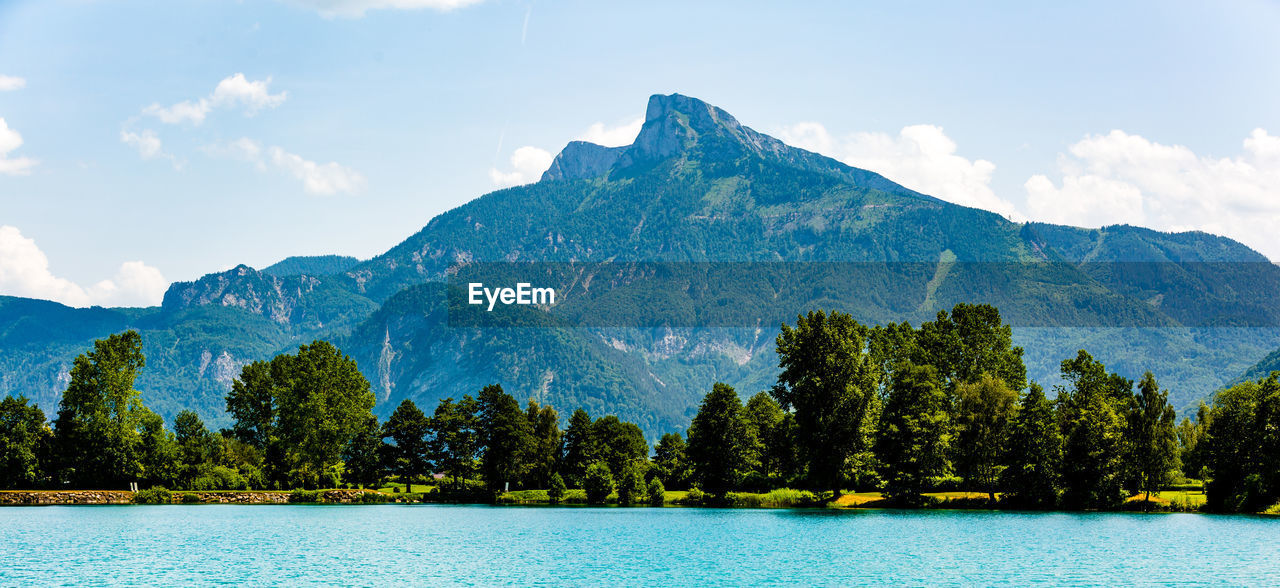 Scenic view of lake by trees against sky