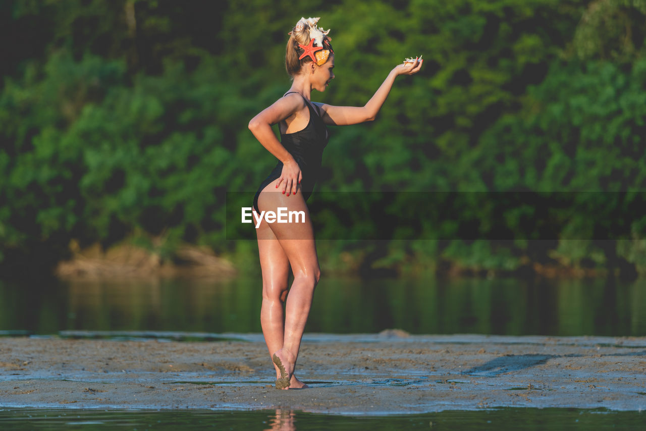 Midsection of woman jumping in water