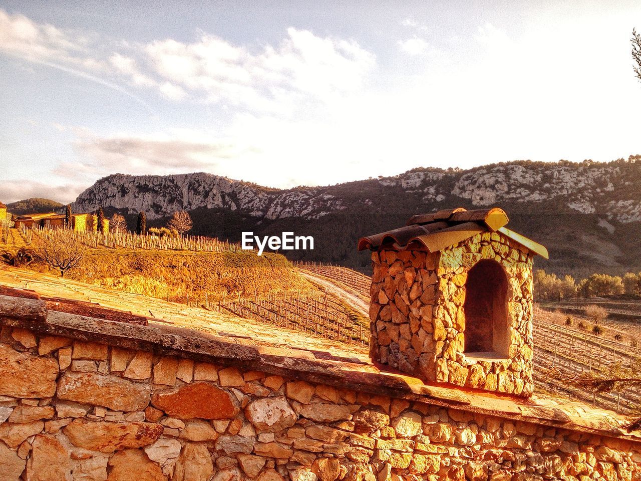 BUILT STRUCTURE ON LANDSCAPE AGAINST MOUNTAIN RANGE