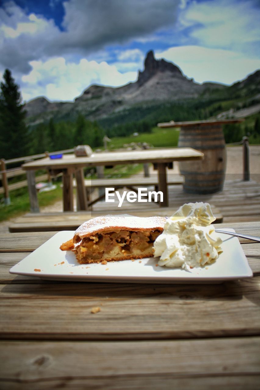 CLOSE-UP OF FOOD ON TABLE AGAINST MOUNTAINS