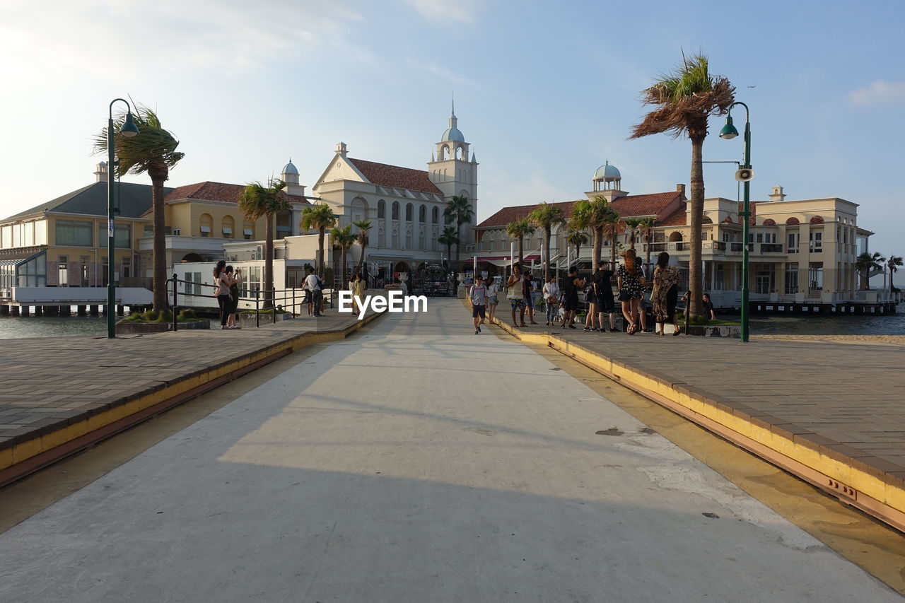 Group of people on road by buildings in city