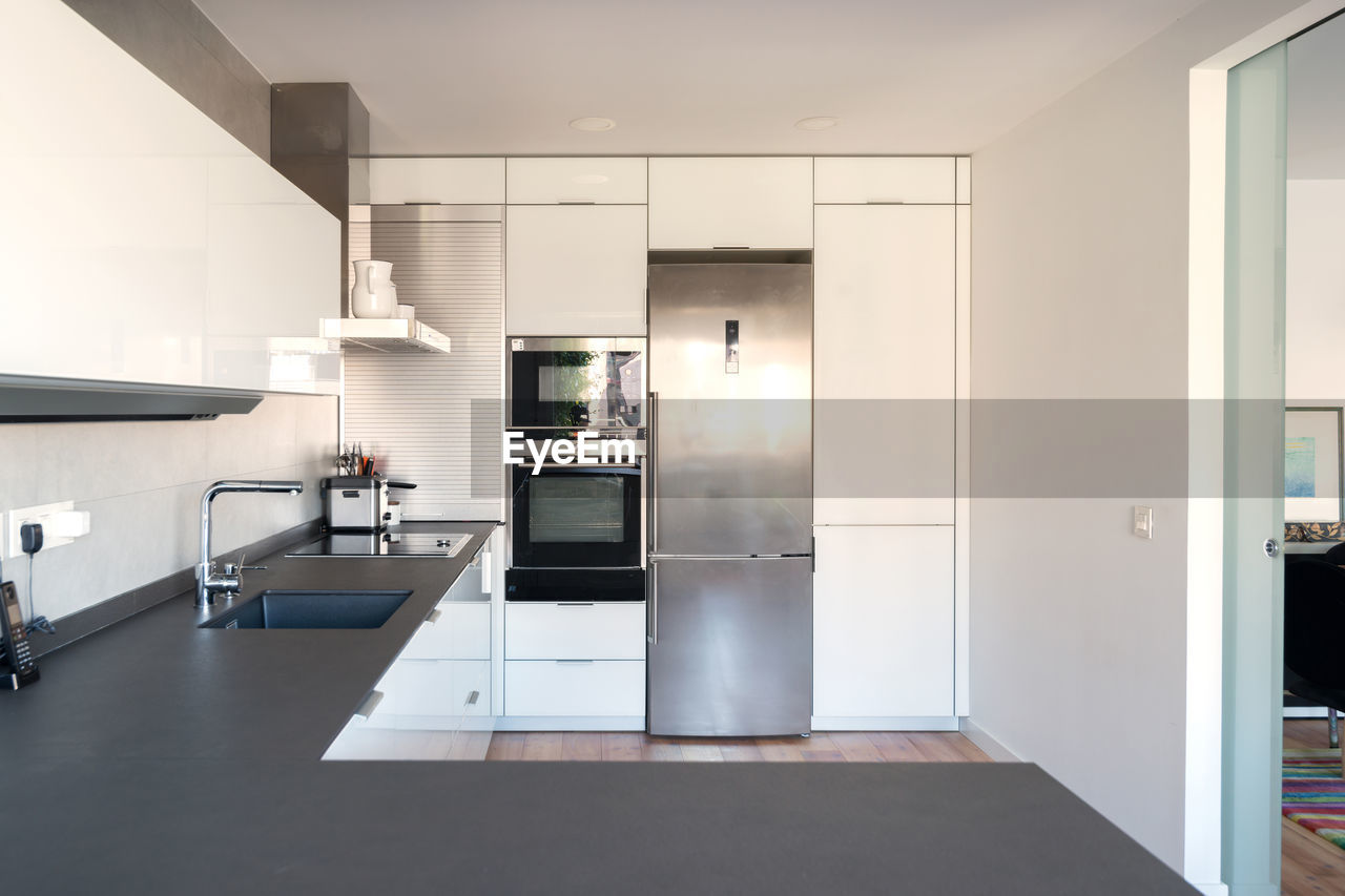 Modern kitchen with white cupboards and black countertop