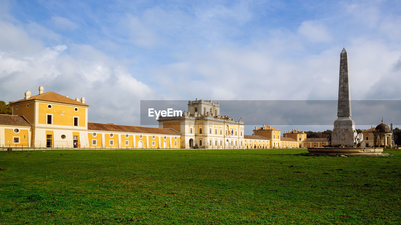 BUILDINGS AGAINST CLOUDY SKY IN LAWN