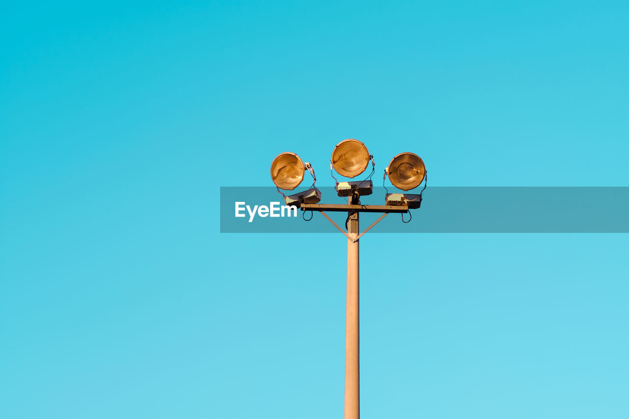 Low angle view of street light against blue sky