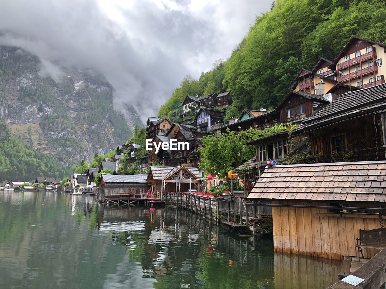 Houses by river and buildings against sky