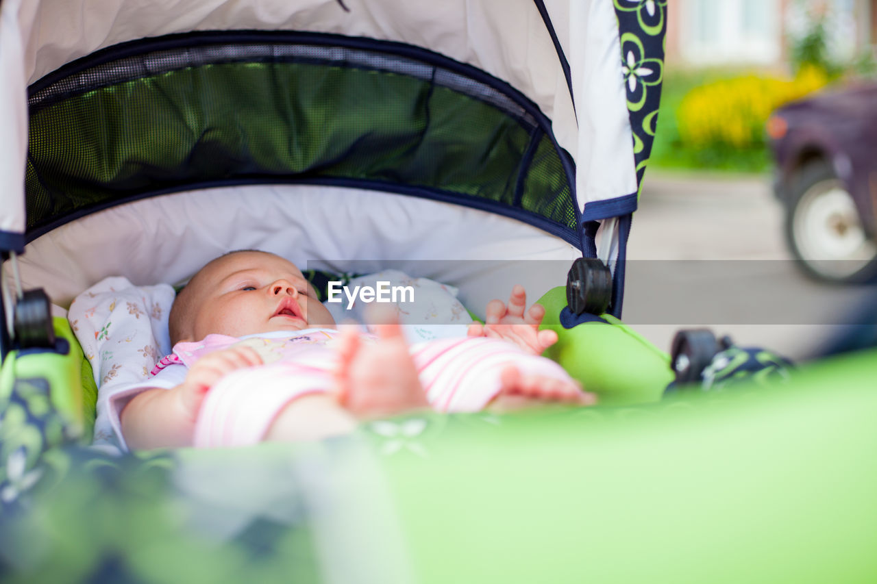 Cute baby lying down in baby stroller