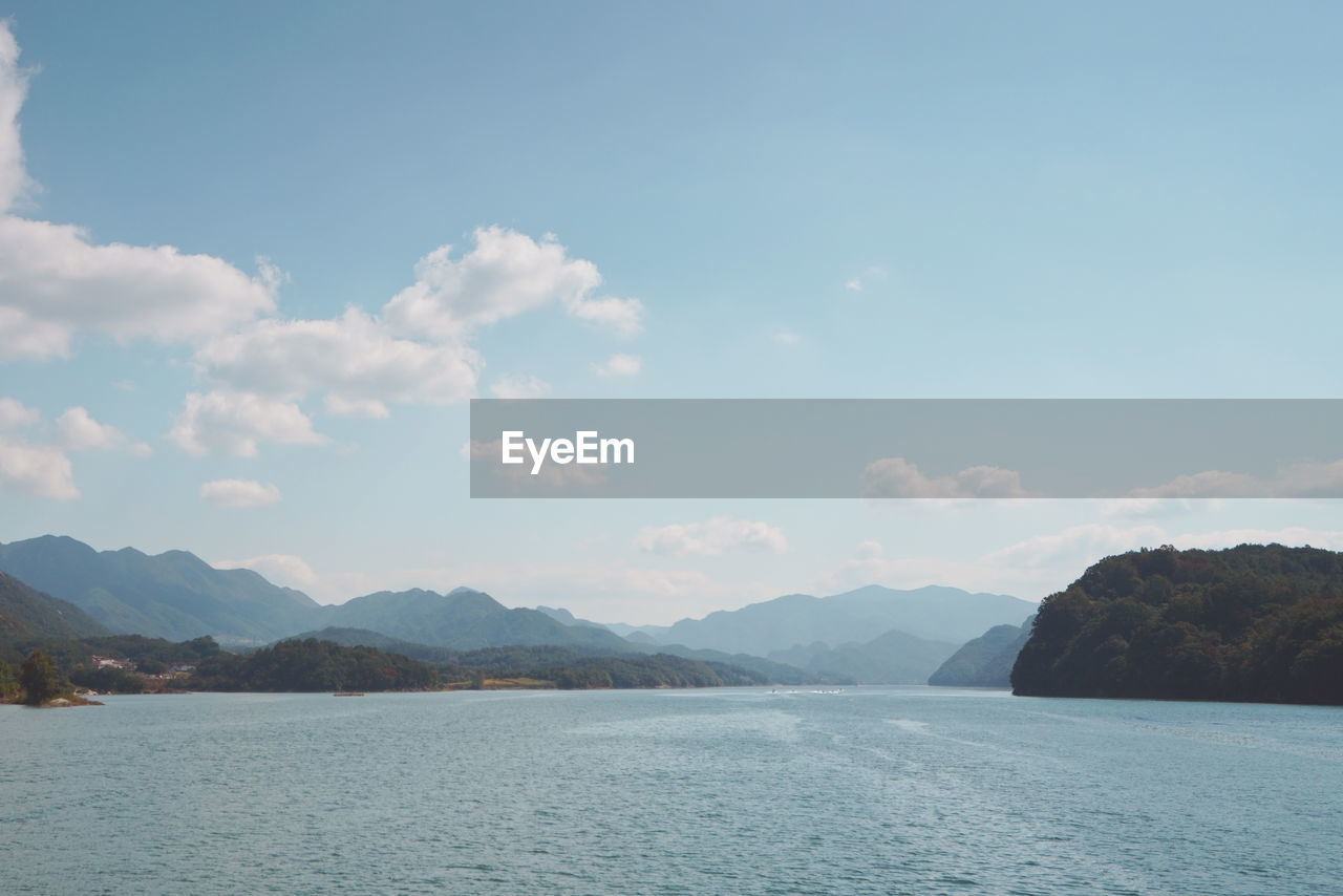 SCENIC VIEW OF SEA AGAINST MOUNTAINS