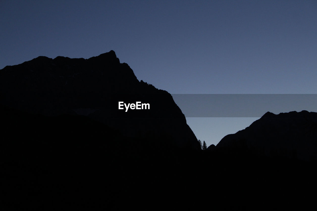 SILHOUETTE OF ROCKY MOUNTAIN AGAINST CLEAR SKY