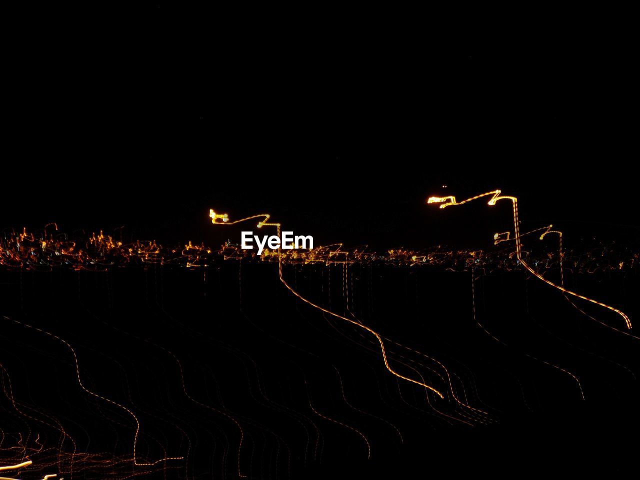 ILLUMINATED ROAD PASSING THROUGH FIELD