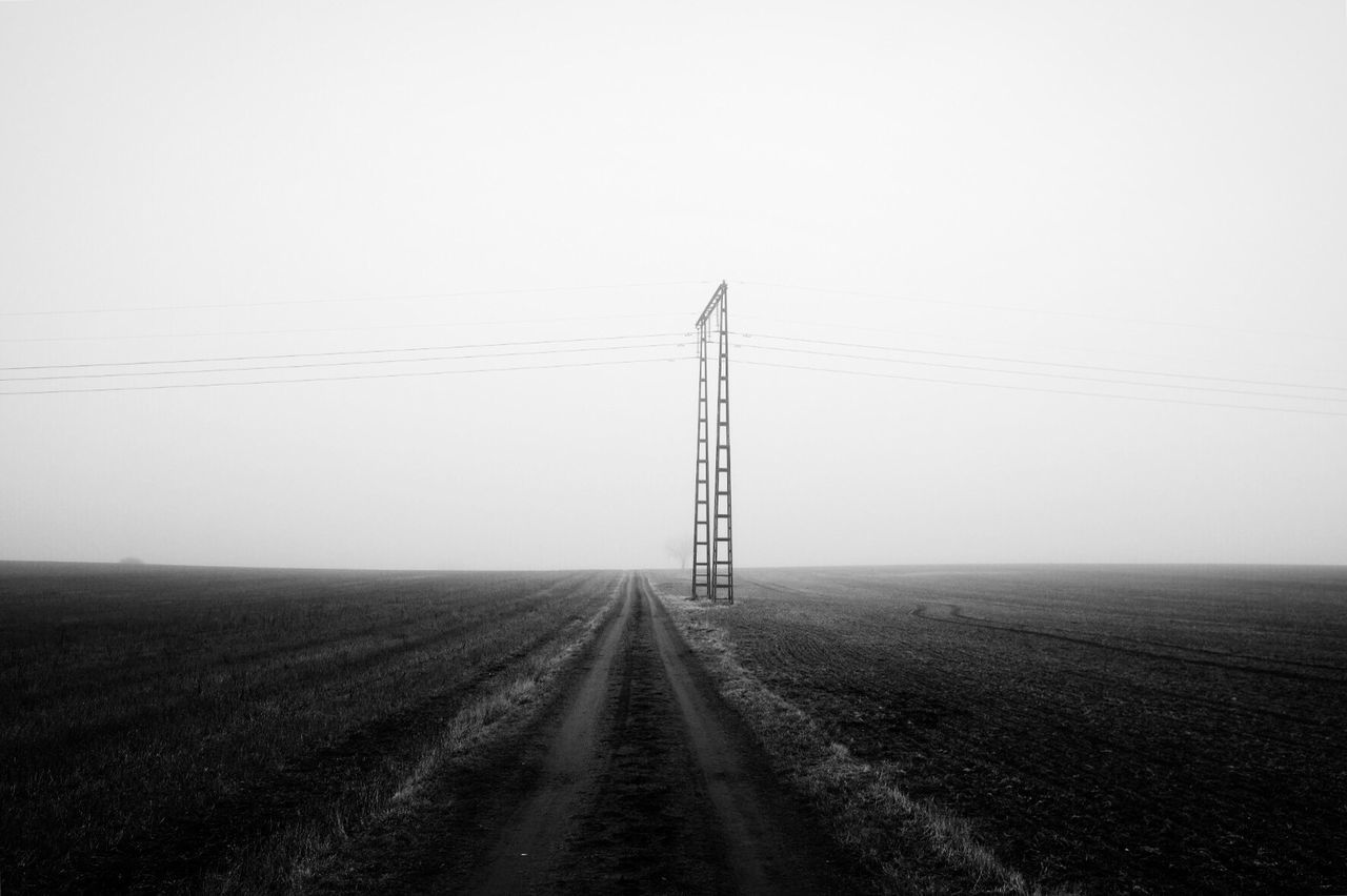 Electricity pylon on field against clear sky