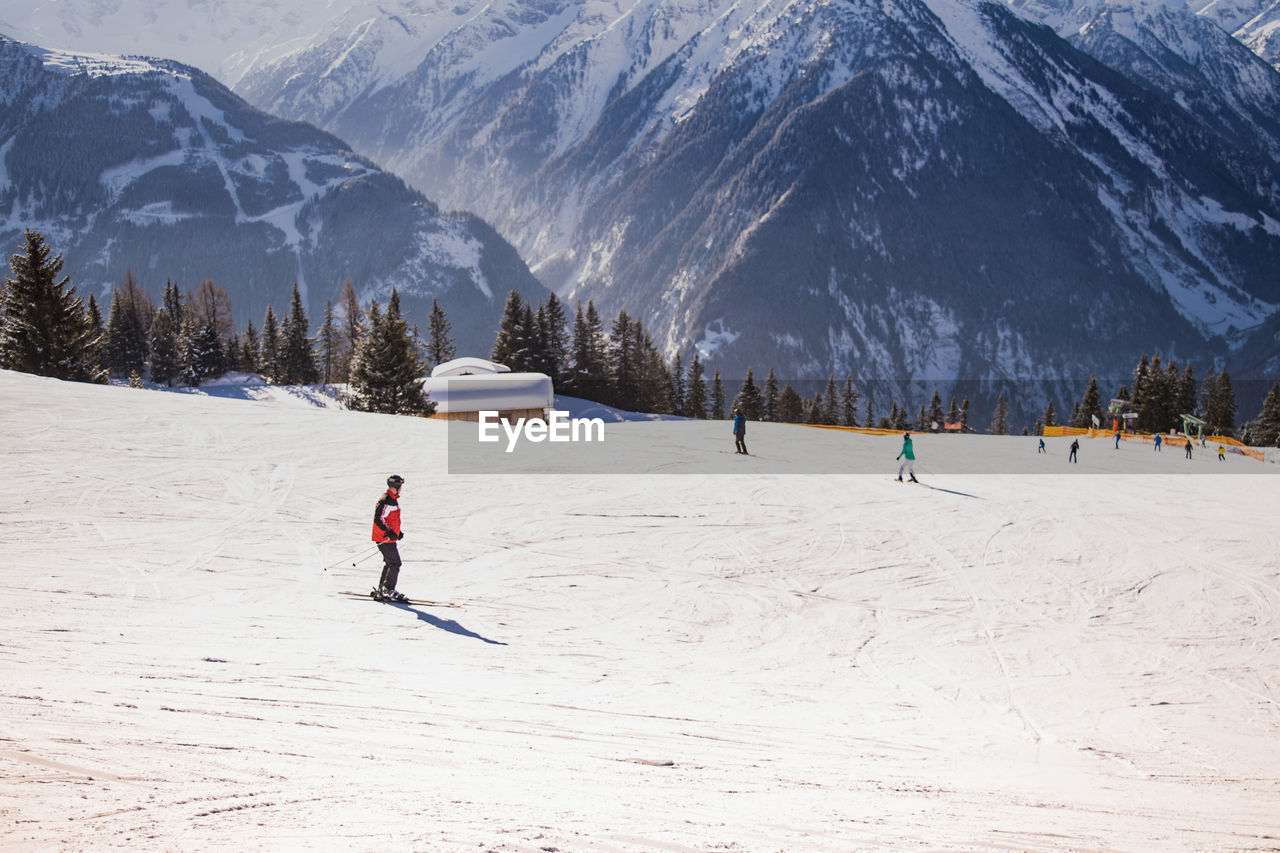 People skiing on snow covered against mountain