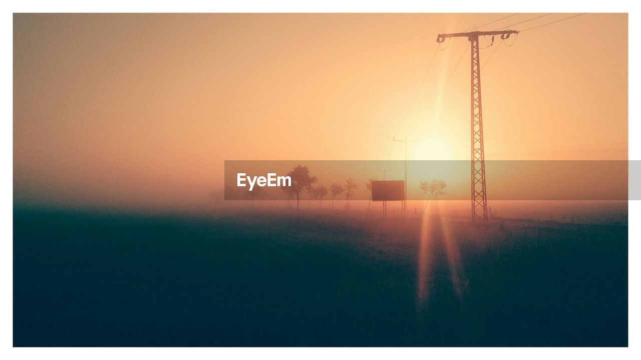 Electricity pylon against sky during sunset