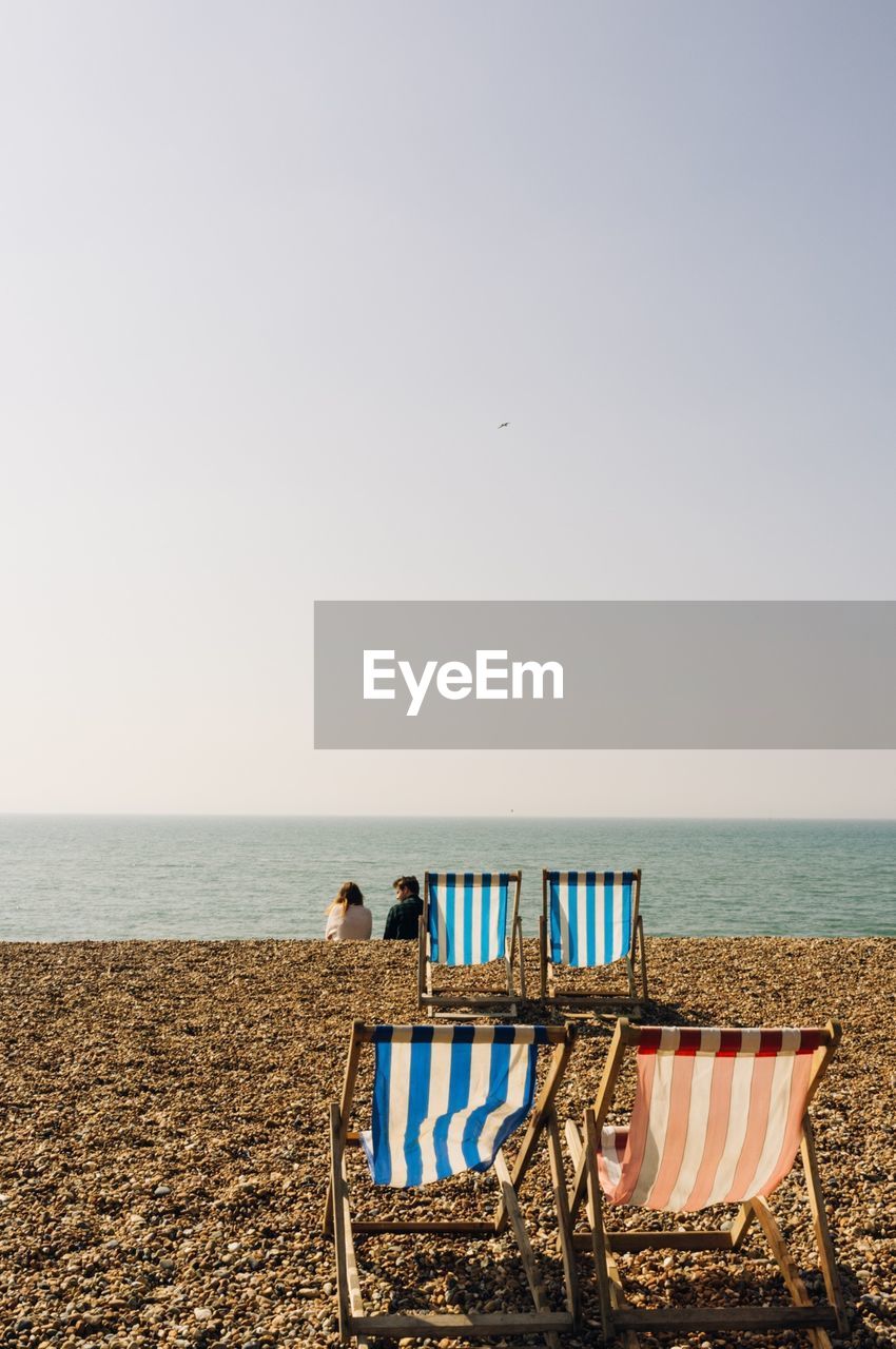 Two people sitting on beach